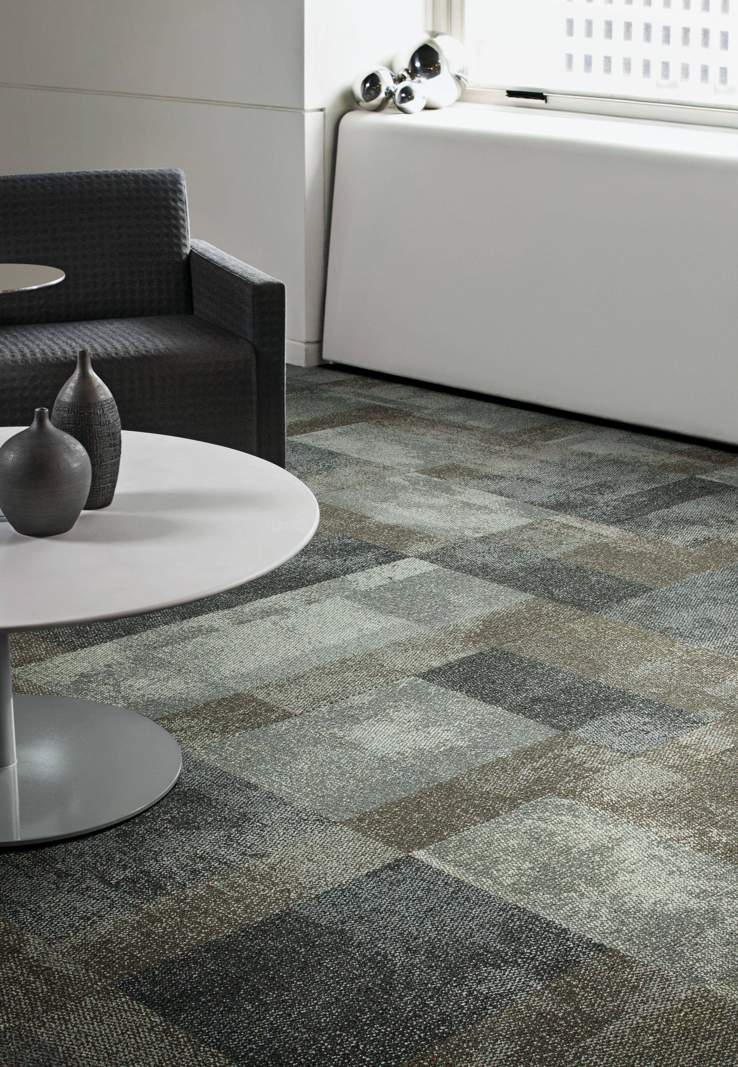 Interface Exposed carpet tile in waiting area with white table and black chair with pottery on table imagen número 1