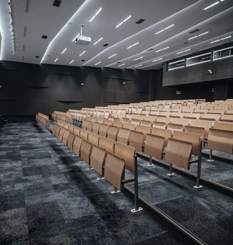 Interface Exposed carpet tile in auditorium with wooden chairs