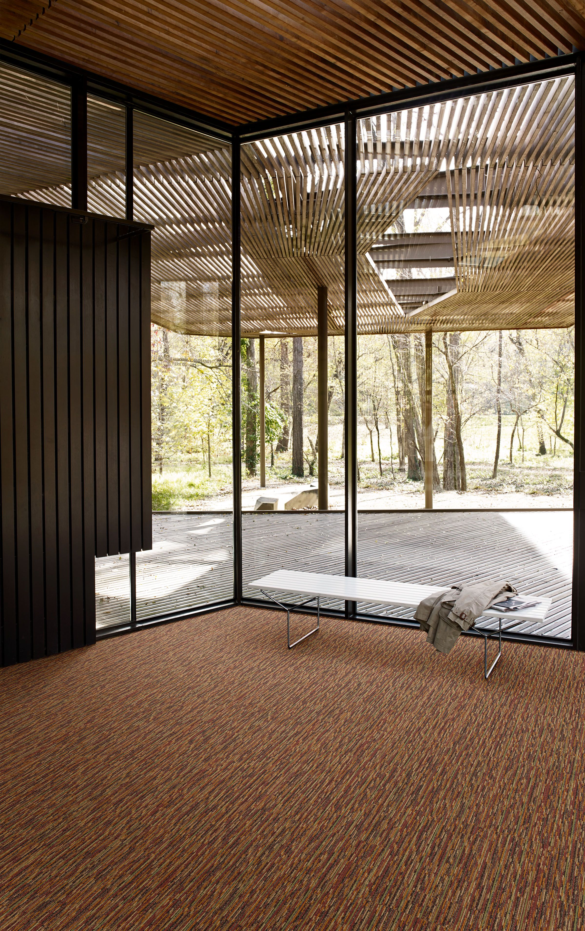 Interface Farmland carpet tile in open area with wood ceiling, wood accent wall and white bench. image number 13
