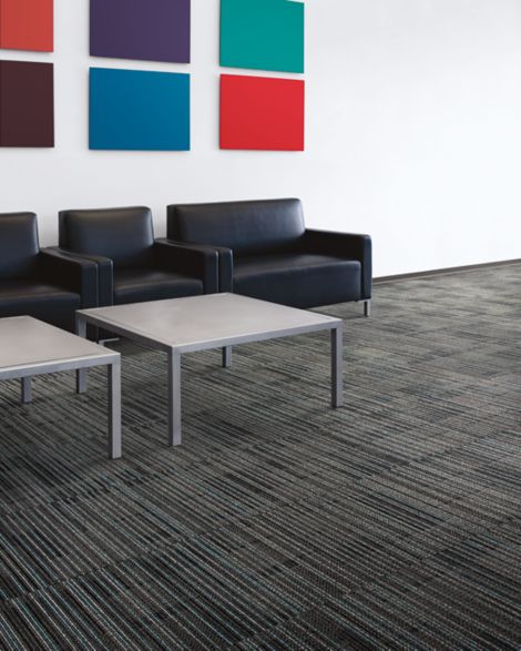 Interface Gather carpet tile in seating area with black chairs and colorful artwork