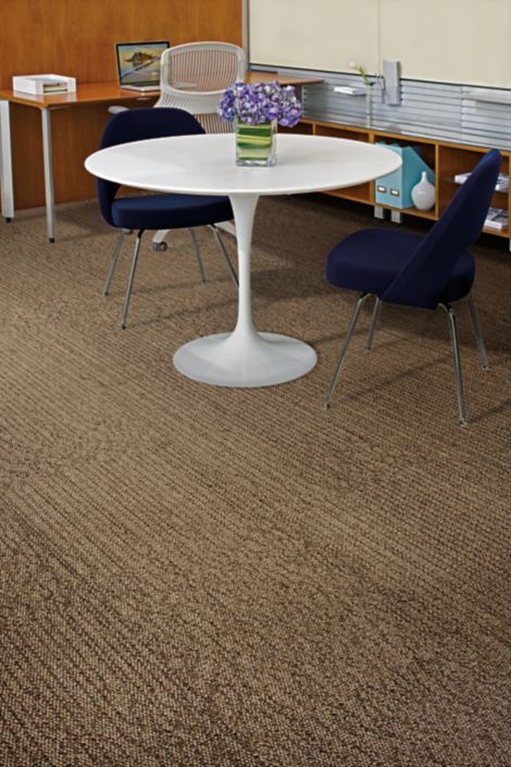 Detail of Interface Grasmere carpet tile with white table and blue chairs