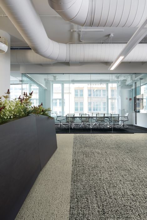 Interface Gridlock, Riverwalk and Edge carpet tile outside of conference room with glass wall
