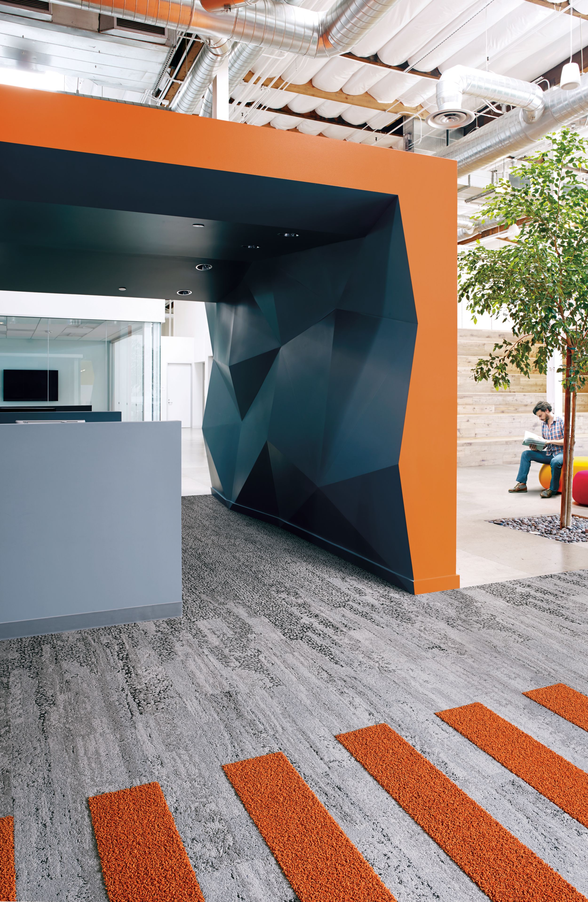 Interface HN810, HN830, HN840 and HN850 plank carpet tiles in blue and orange covered space with man reading on ball chair número de imagen 5