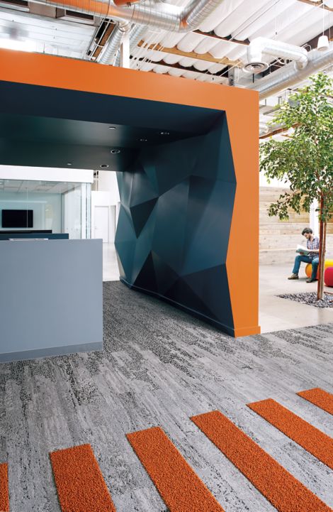 Interface HN810, HN830, HN840 and HN850 plank carpet tiles in blue and orange covered space with man reading on ball chair imagen número 4