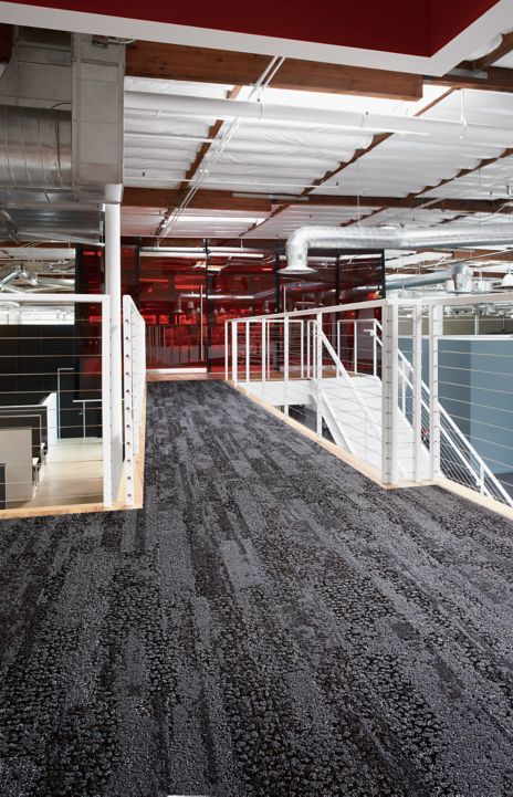 Interface HN850 plank carpet tile in upper level open stairwell with red glass meeting room in background image number 1