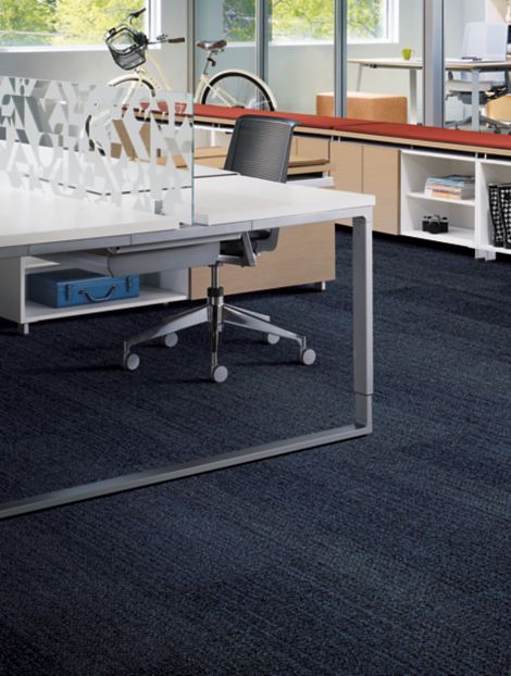 Interface Harmonize plank carpet tiles in workspace area with open desk, red covering on shelf and bike in background imagen número 6