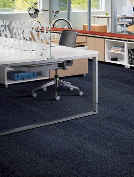 Interface Harmonize plank carpet tiles in workspace area with open desk, red covering on shelf and bike in background image number 5
