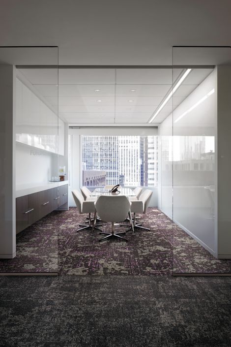 Interface Head in the Clouds carpet tile in meeting room with glass doorway and highrise buildings through window in the background