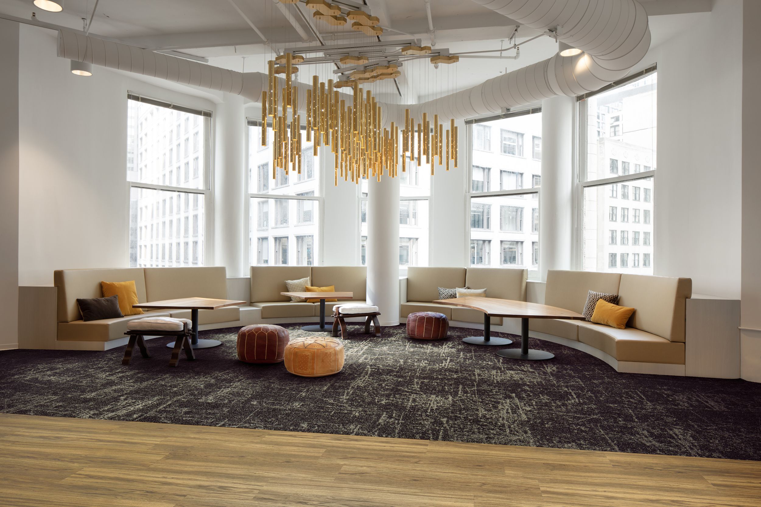 Interface Heartthrob carpet tile in common space with booths in half circle and high rise office building in background imagen número 3