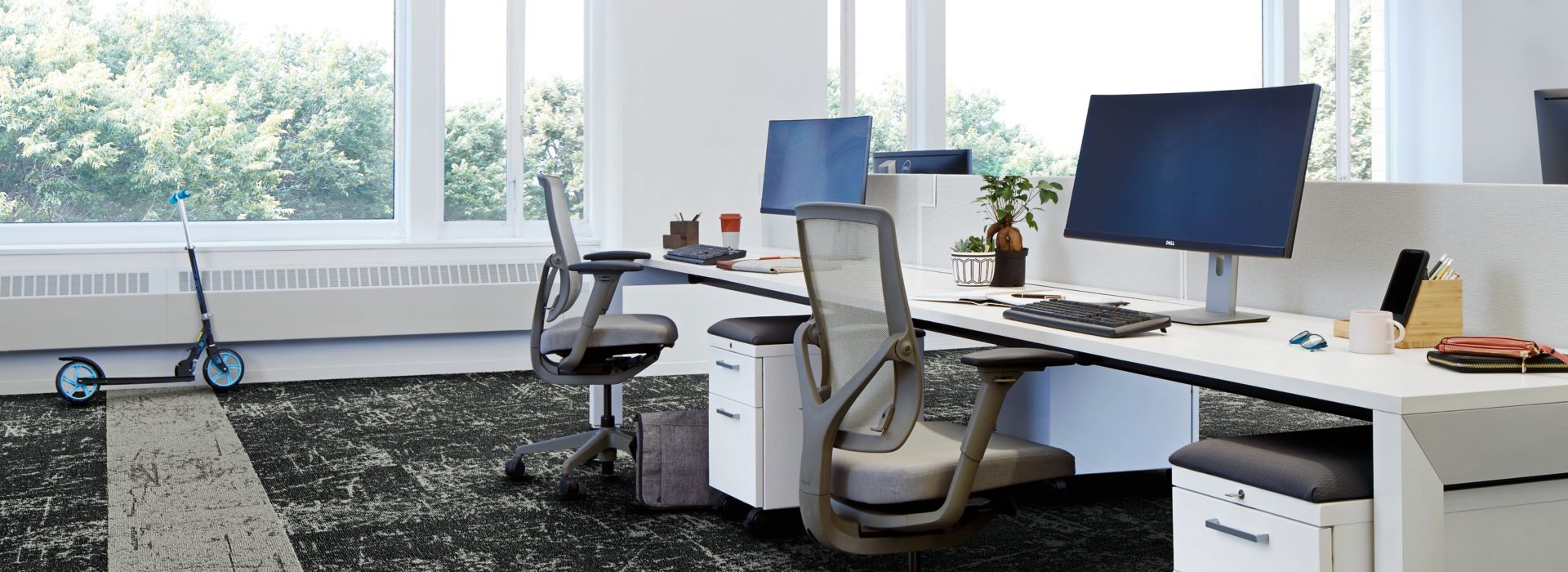 Interface Heartthrob carpet tile in multiple workspaces with computers on desks and scooter in background