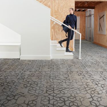 Interface Honey Do carpet tile with woman walking down open stairway and looking back image number 1