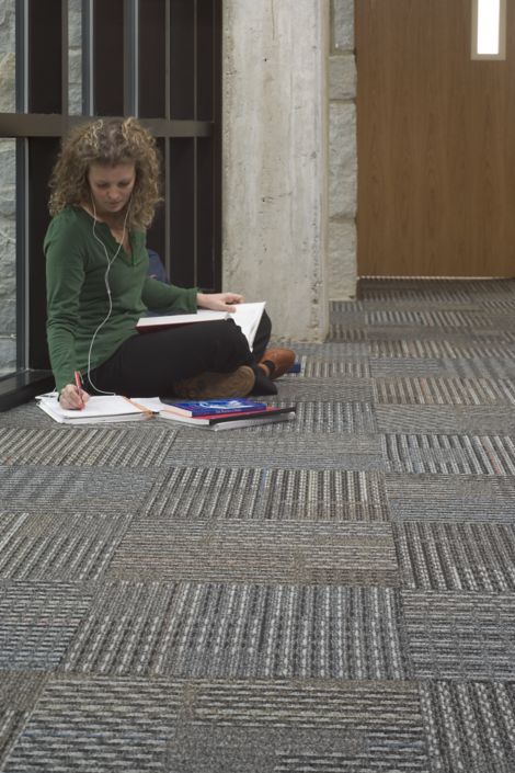 Interface Cotswold II carpet tile in corridor with woman seated and studying image number 7