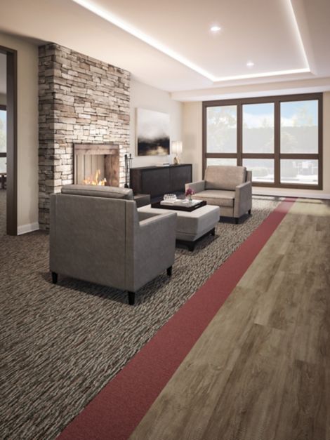 Interface Farmland and Monochrome carpet tile with Textured Woodograins LVT in senior housing seating area with stone fireplace
