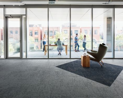 Interface Ice Breaker carpet tile in open room with chair and side table with people on balcony in background imagen número 3