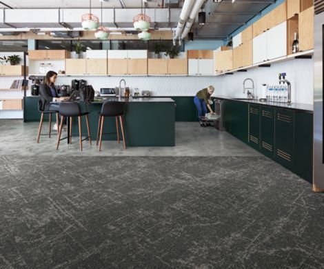 Interface Ice Breaker carpet tile and Textured Stones LVT in kitchen area with women lodaing dish washer and women working on computer image number 3