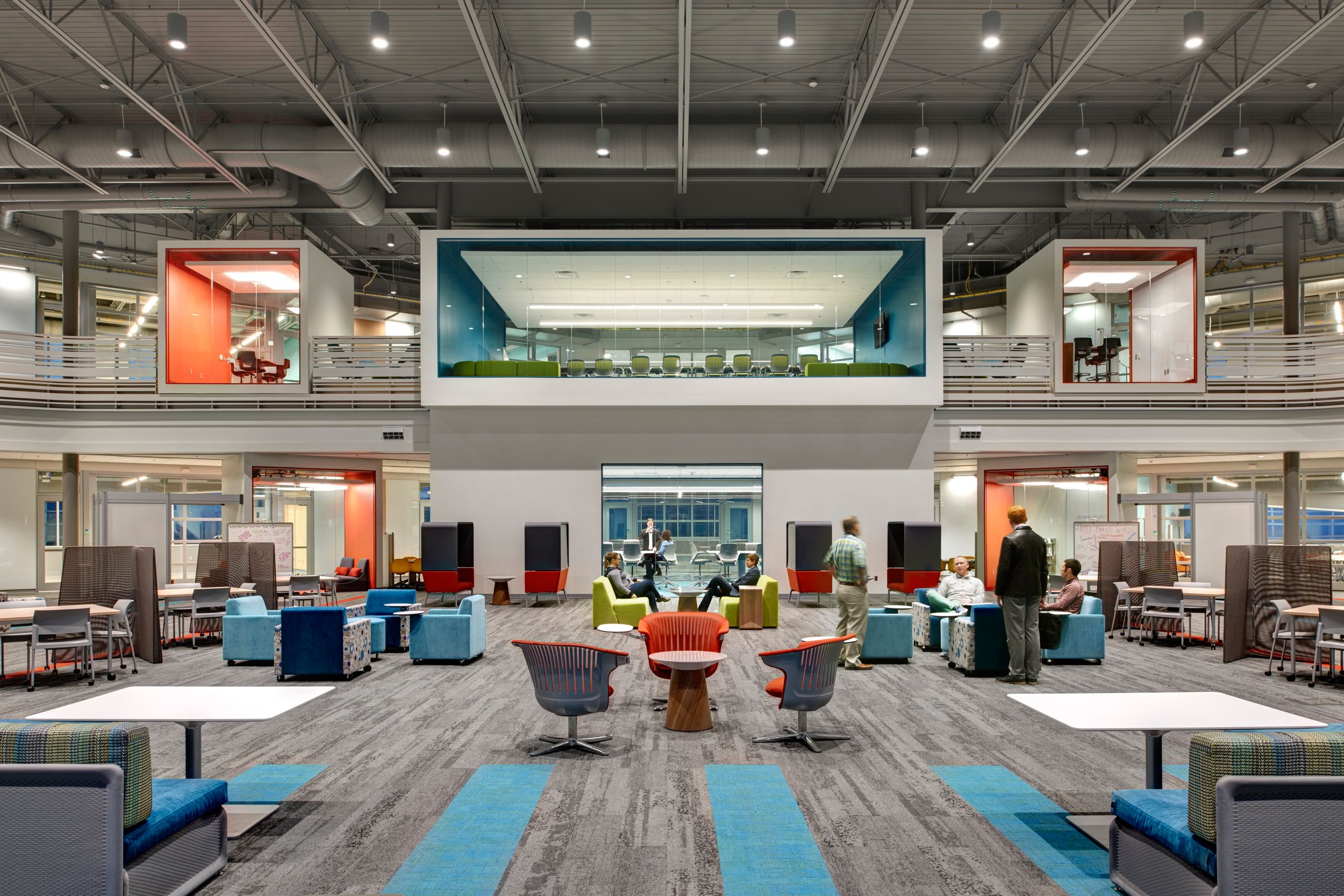 Interface HN810, HN820 and HN850 plank carpet tiles in first floor view of open office space with employees working and glass meetings rooms in the back on second floor numéro d’image 10