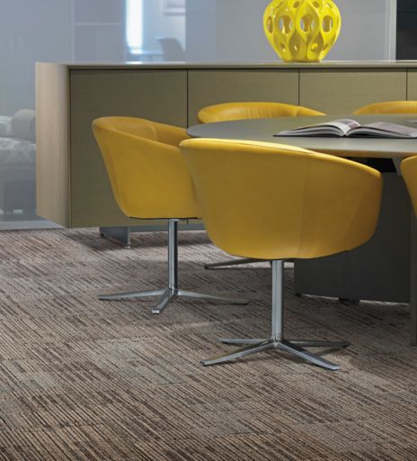 Interface Mantra carpet tile in seating area with round table and yellow chairs