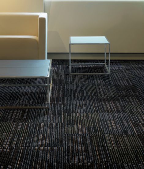 Interface Mantra carpet tile in waiting room with couch, console table, and side table