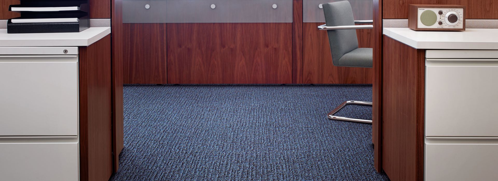 Interface Menagerie II carpet tile in office area with white cabinets and wooden cubicles