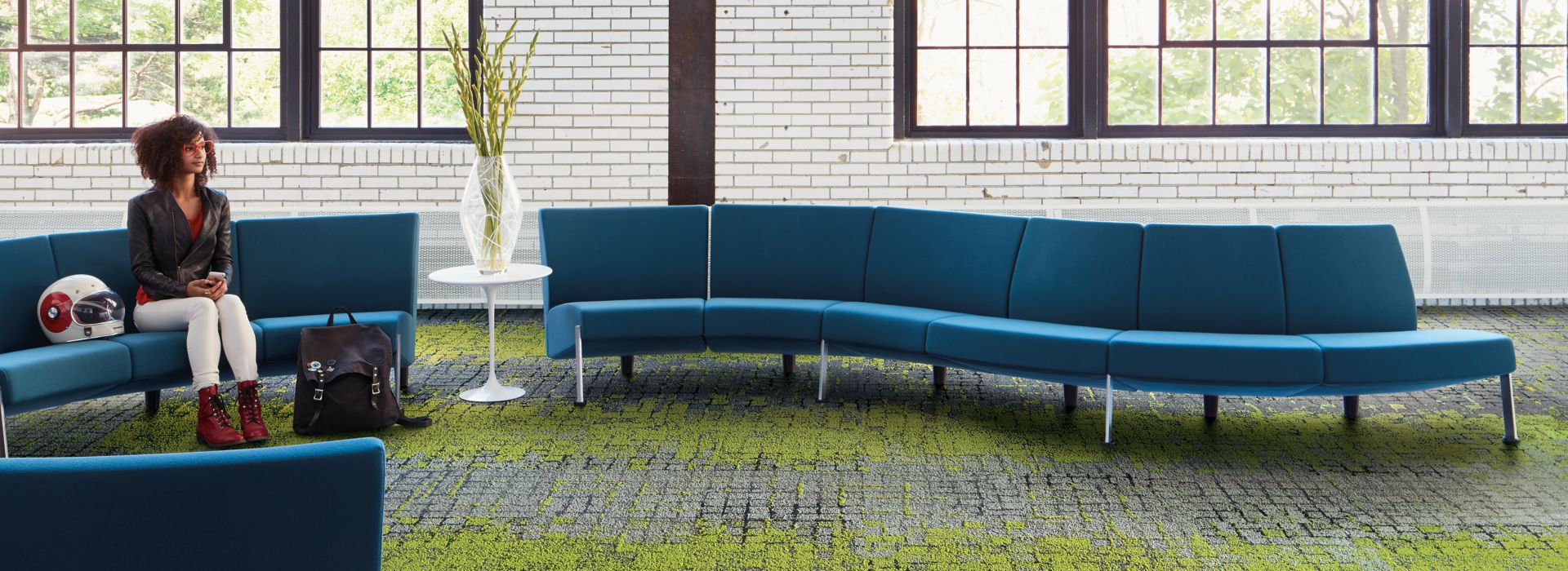 Interface Moss and Moss in Stone carpet tile in seating area with blue couches and women seated