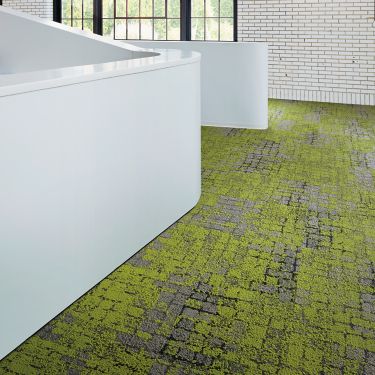 Interface Moss carpet tile in open area with brick wall and glass window in background