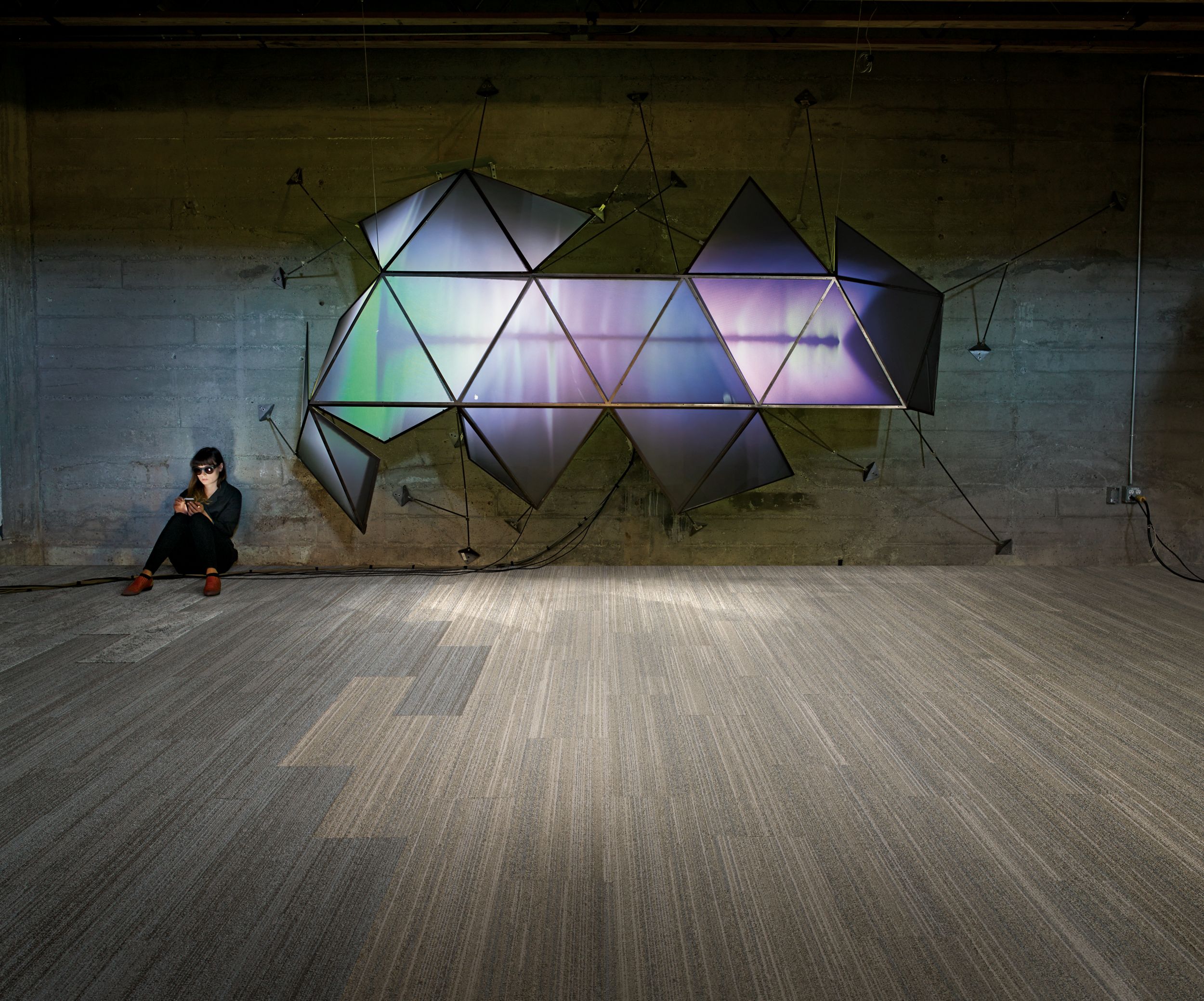 image Interface NF400 and HN810 plank carpet tile in open public space with woman sitting against brick wall on phone beside wall fixture numéro 5