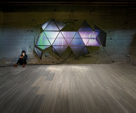 Interface NF400 and HN810 plank carpet tile in open public space with woman sitting against brick wall on phone beside wall fixture image number 5