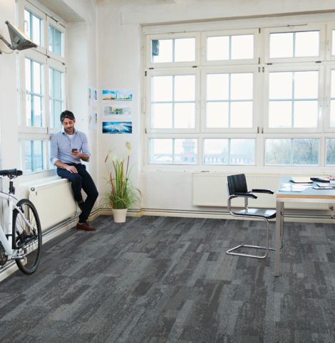 Interface Naturally Weathered plank carpet tile in office space with man looking at phone on window sill image number 3