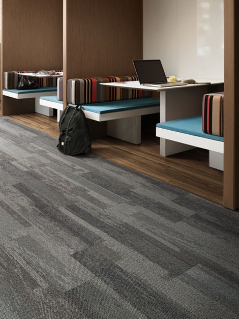 Interface Naturally Weathered plank carpet tile and Natural Woodgrains LVT in office with laptop and backpack in booth seating imagen número 6
