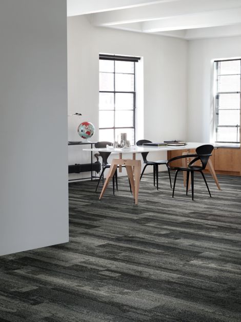 Interface Naturally Weathered plank carpet tile in office space with desk and world globe
