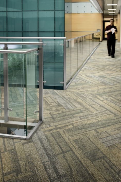 Interface Neighborhood Blocks plank carpet tile in office corridor with glass railing