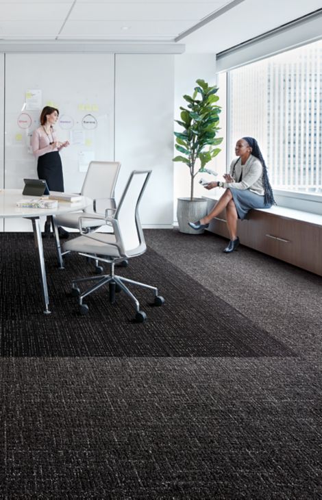 Interface Night Flight carpet tile and Haptic plank carpet tile in office working space with two women talking