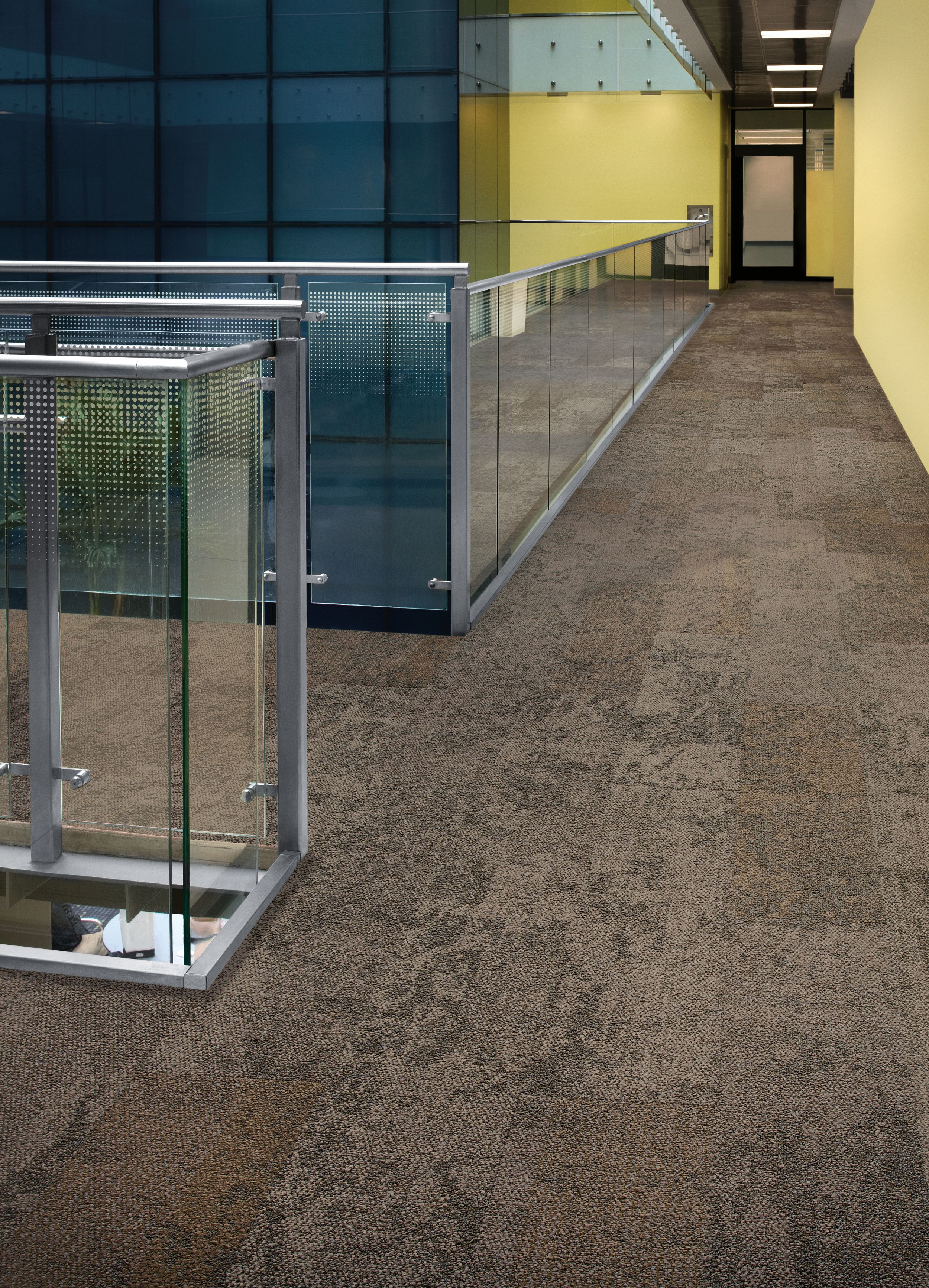 Interface Nimbus carpet tile plank in corridor with glass railing and yellow walls imagen número 1