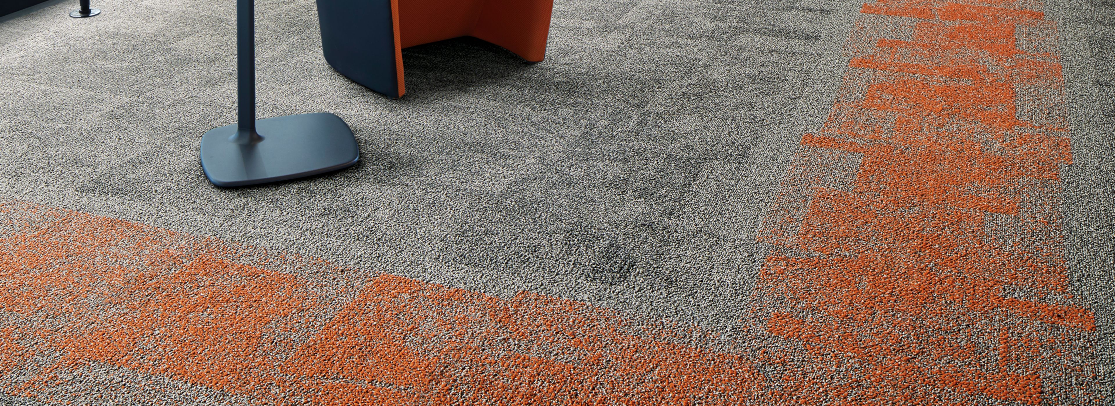 Interface Open Air 404 carpet tile in corner space with open cement ceiling and orange chairs image number 1