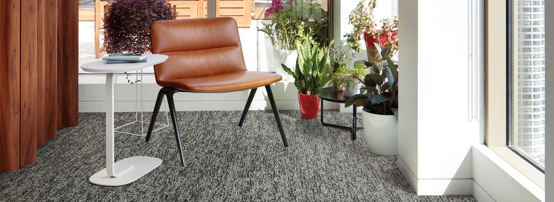 Interface Obligato plank carpet tile with leather chair and potted plants in windows