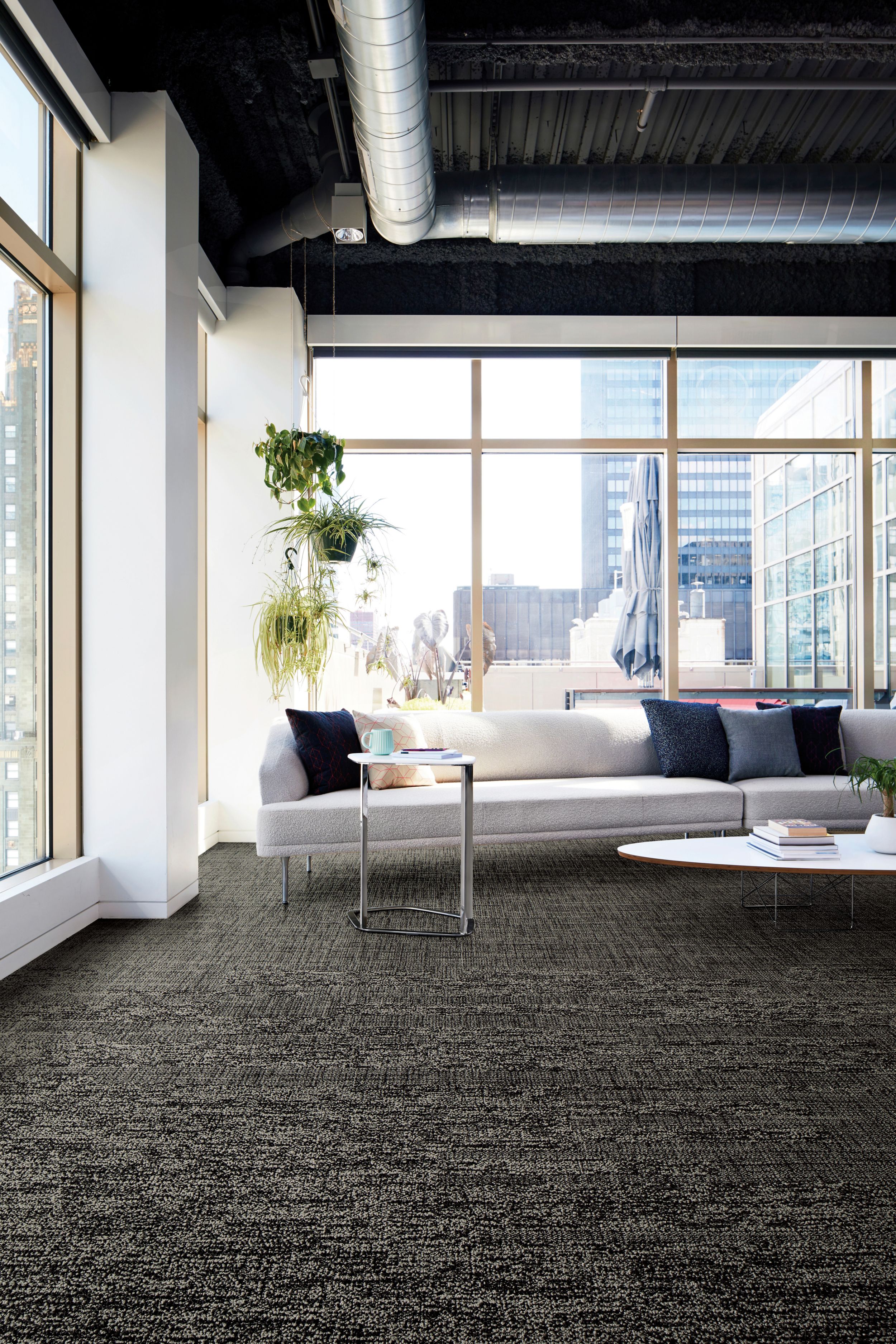 Interface Obligato plank carpet tile in corner space with long white fabric couch and end table with coffee mug image number 7