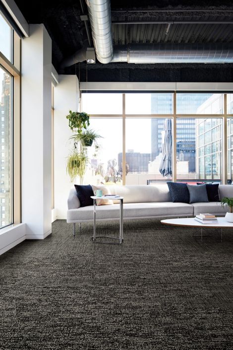 Interface Obligato plank carpet tile in corner space with long white fabric couch and end table with coffee mug imagen número 7