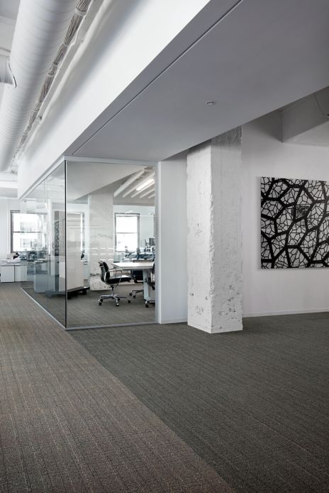 Interface Old Street carpet tile with rough white concrete colum and glass corner office