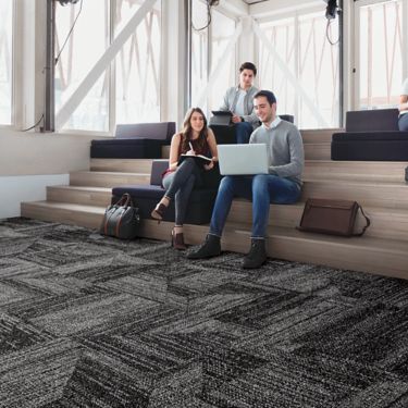 Interface Open Air 403 carpet tile with group working on built in wood stairs
