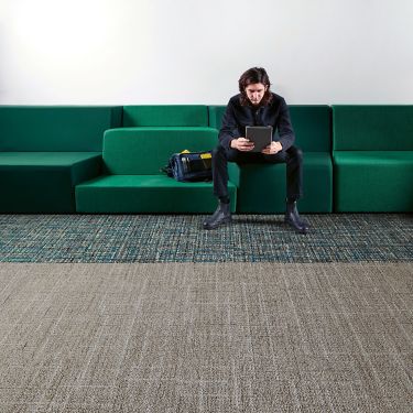 Interface Open Air 401 plank carpet tile with man working on tablet sitting on long green couch numéro d’image 1