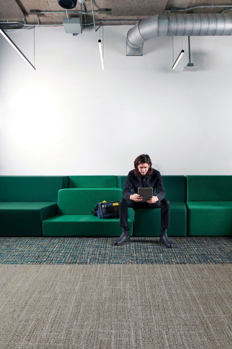 Interface Open Air 401 plank carpet tile with man working on tablet sitting on long green couch image number 5