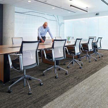 Interface Open Air 402 plank carpet tile with man working on laptop at conference table