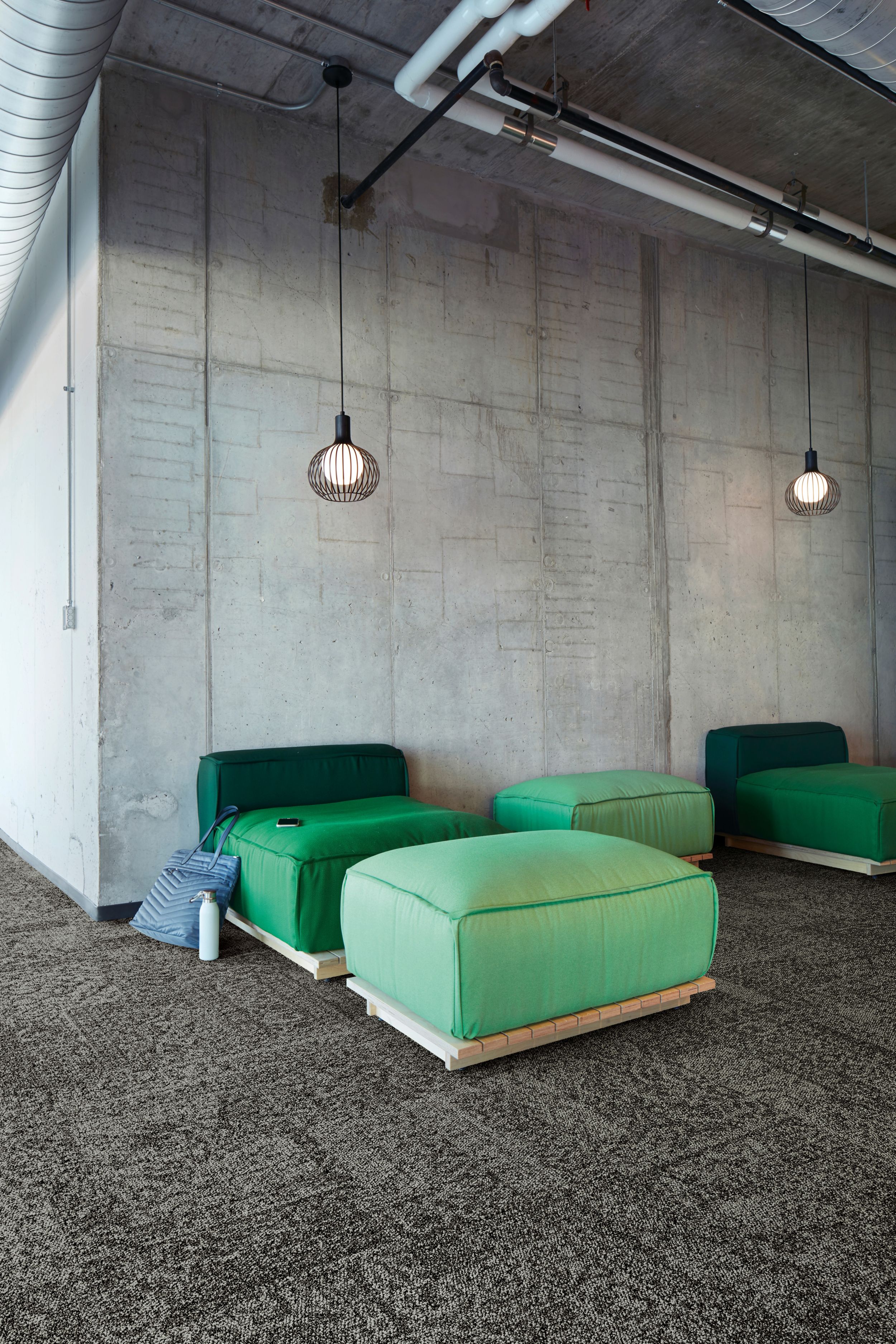 Interface Open Air 405 carpet tile with cement wall and green puffy chairs and ottomans image number 1