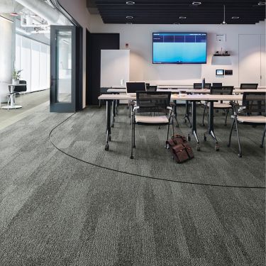 Interface Open Air 410 plank carpet tile in open conference room with satchel leaning on chair