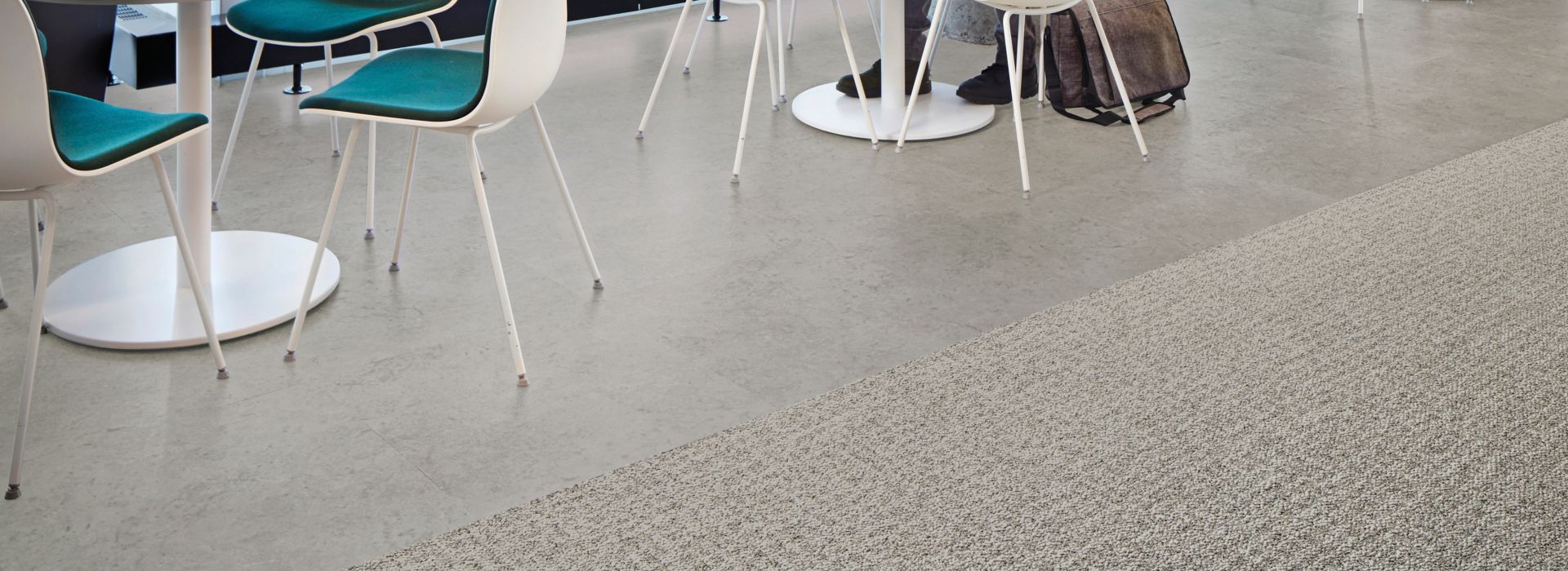 Interface Open Air 415 carpet tile in dining space with man working on laptop at white table