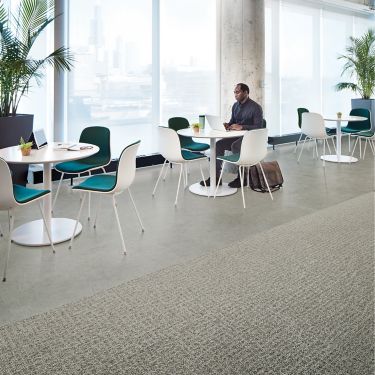 Interface Open Air 415 carpet tile in dining space with man working on laptop at white table imagen número 1