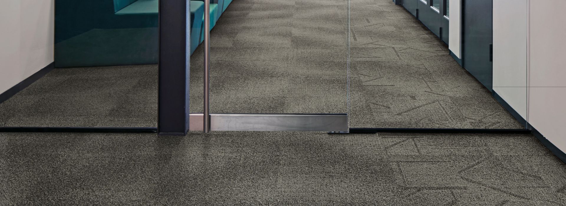 Interface Open Air 416 carpet tile with glass doorway and man working on computer in background