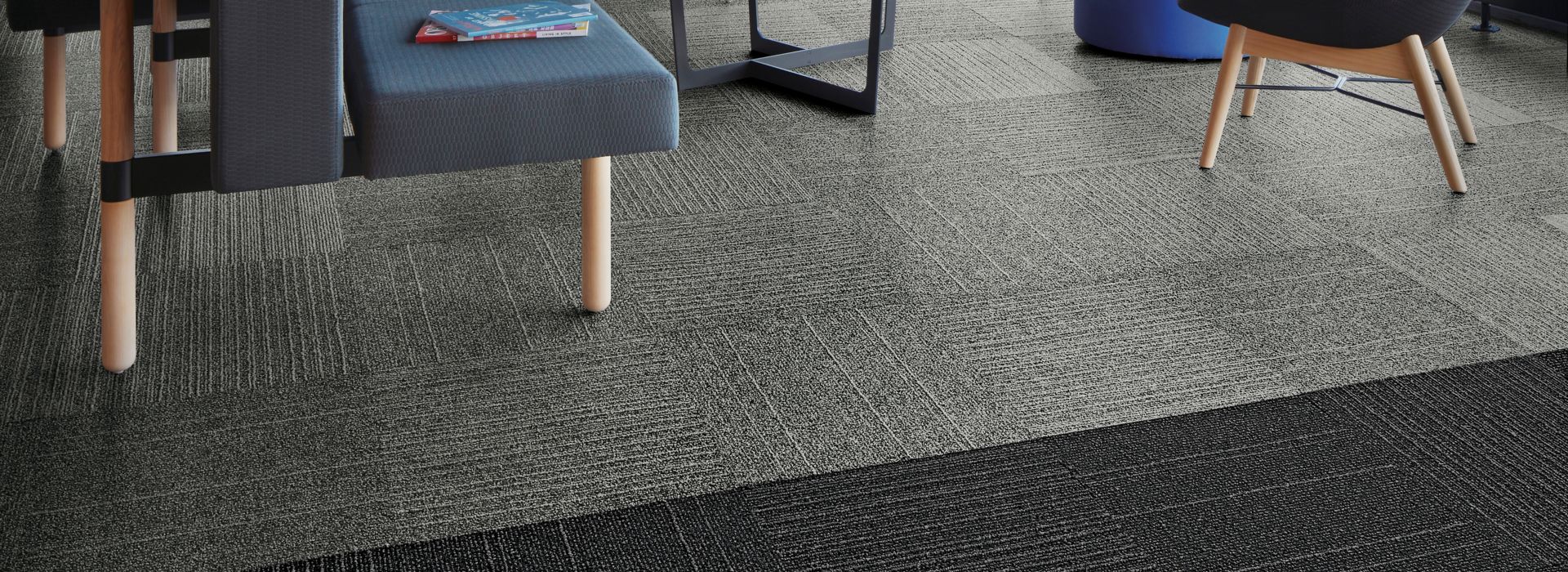 Interface Open Air 423 carpet tile in social space with blue seating and floor to ceiling windows