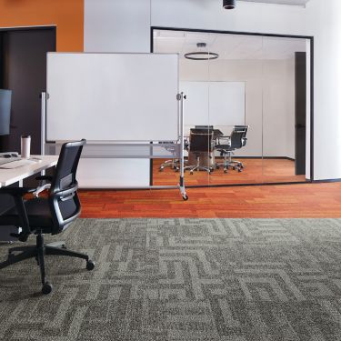 Interface Open Air 414 carpet tile with AE317 plank carpet tile in corner workstation with whiteboard and meeting room in background