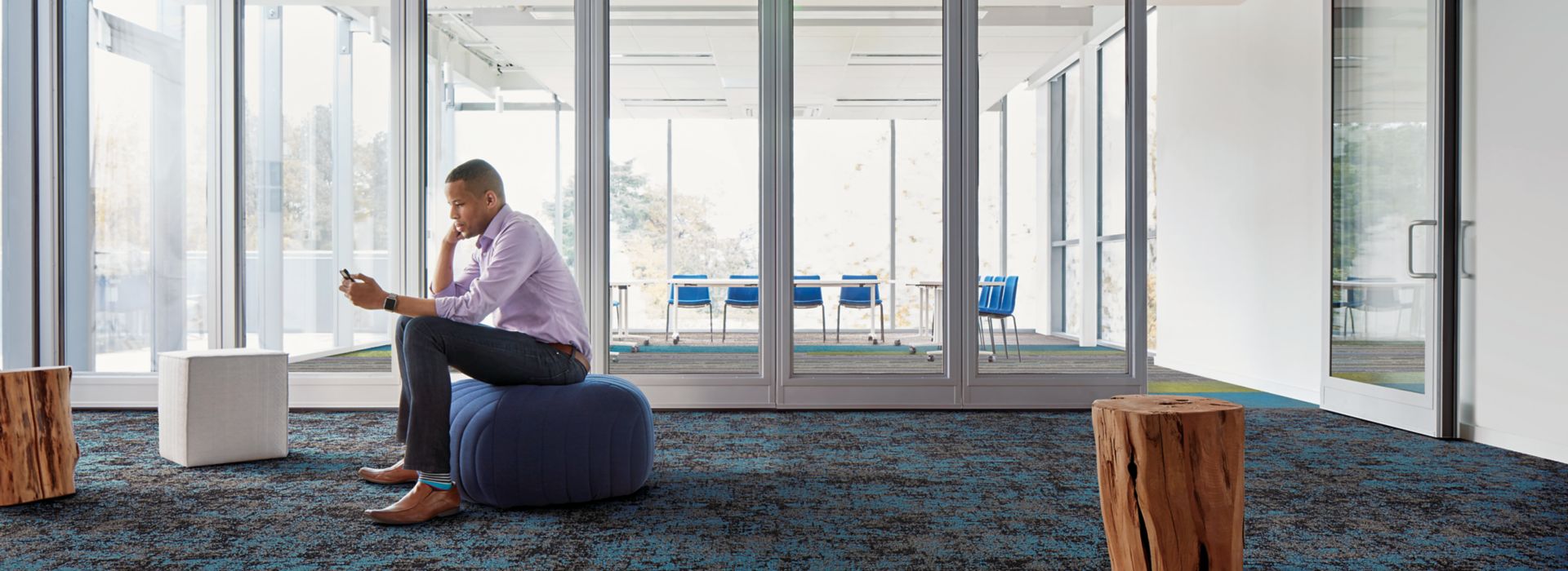 Interface Painted Gesture, Video Spectrum, and Shaded Pigment plank carpet tile in open room with man seated looking at phone